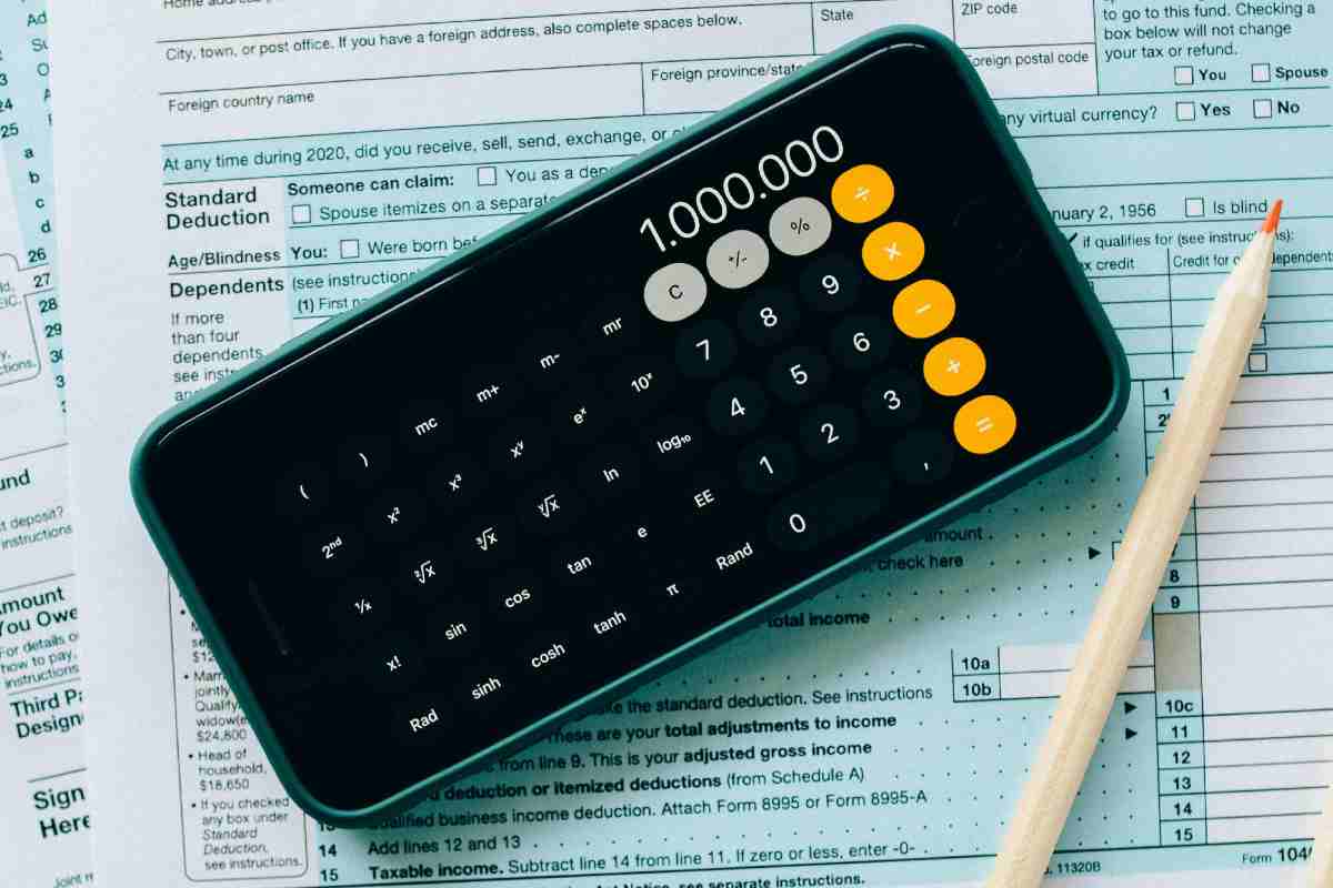 Una calcolatrice su uno smartphone appoggiato su dei documenti fiscali